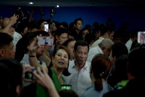Crowds surrounding a Filipino man