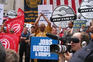an ACORN political activist speaks in front of crowd and fellow supporters waiving signs