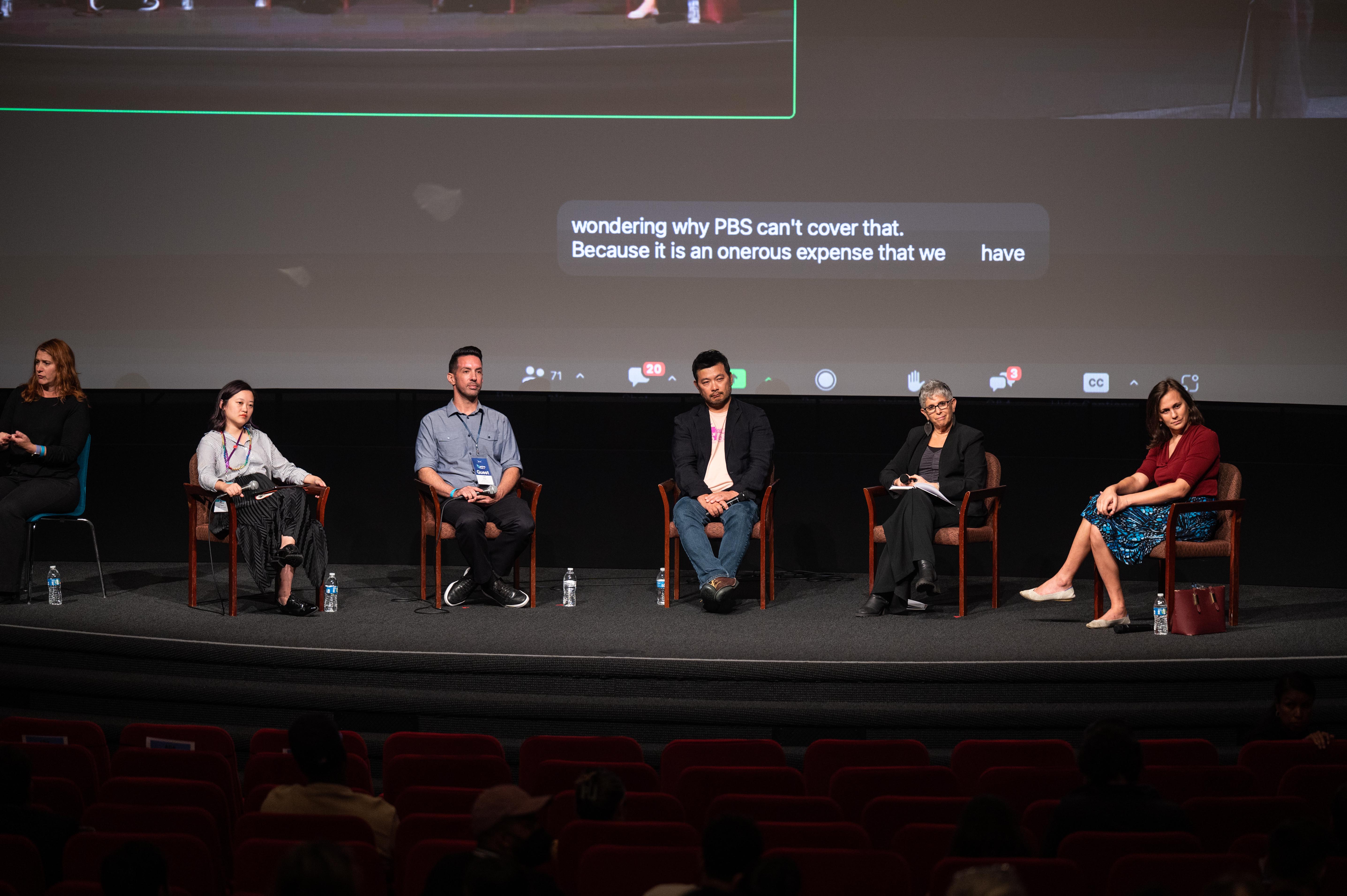 Five people sit on stage.